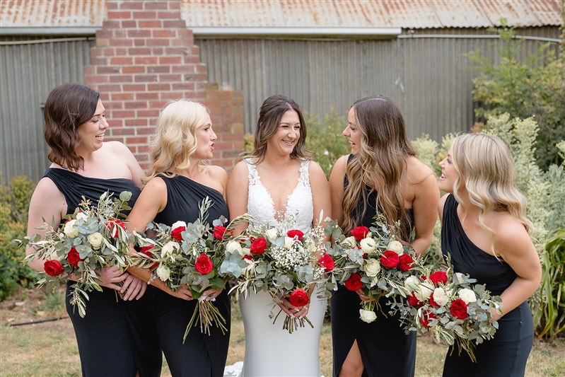 Bride and bridesmaid group with matching red-toned florals