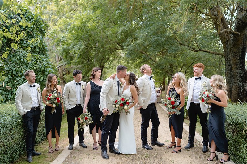 Bridal party posing together under leafy canopy