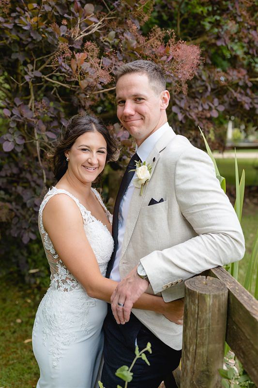 Bride and groom smiling together in garden setting