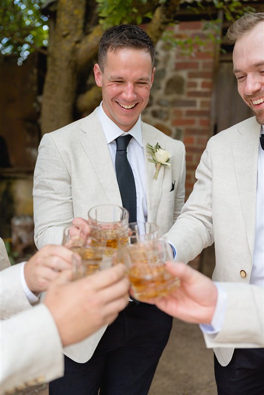 Groom toasting with groomsmen over whisky before ceremony