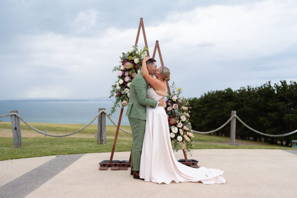 Bride and groom embracing with bouquet at Jack Rabbit Vineyard wedding
