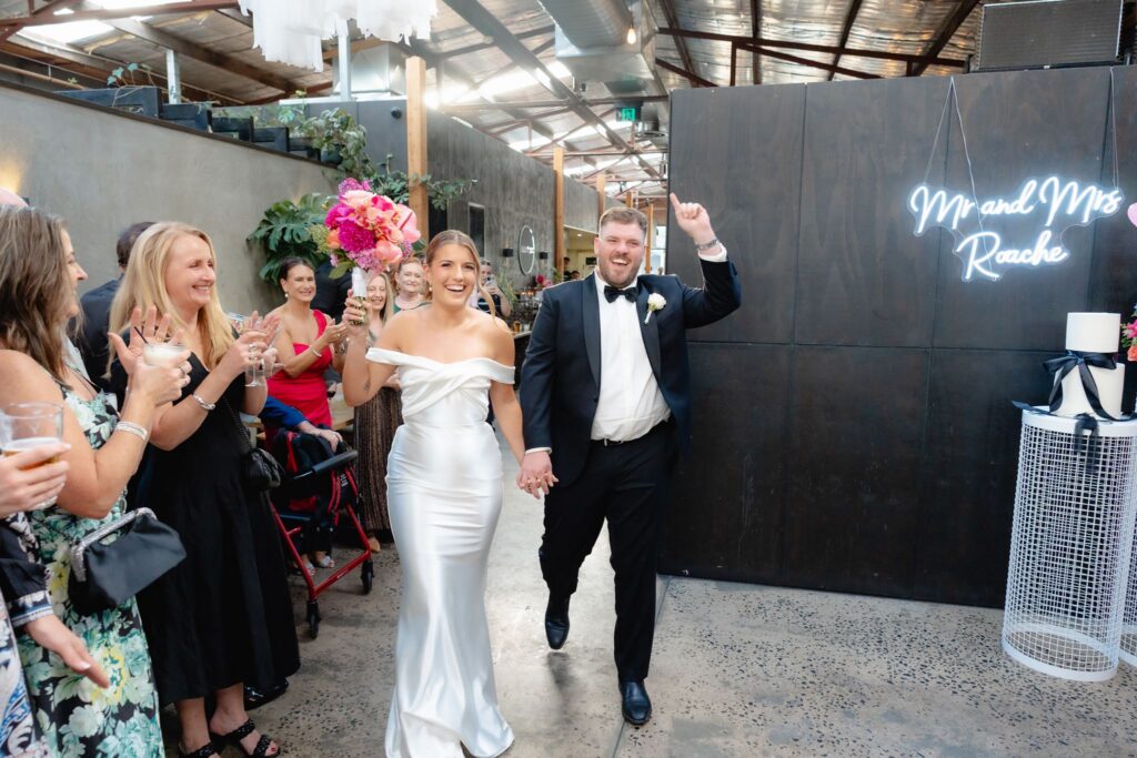 Bride and groom at the Mr and Mrs neon sign at Industry26 wedding reception