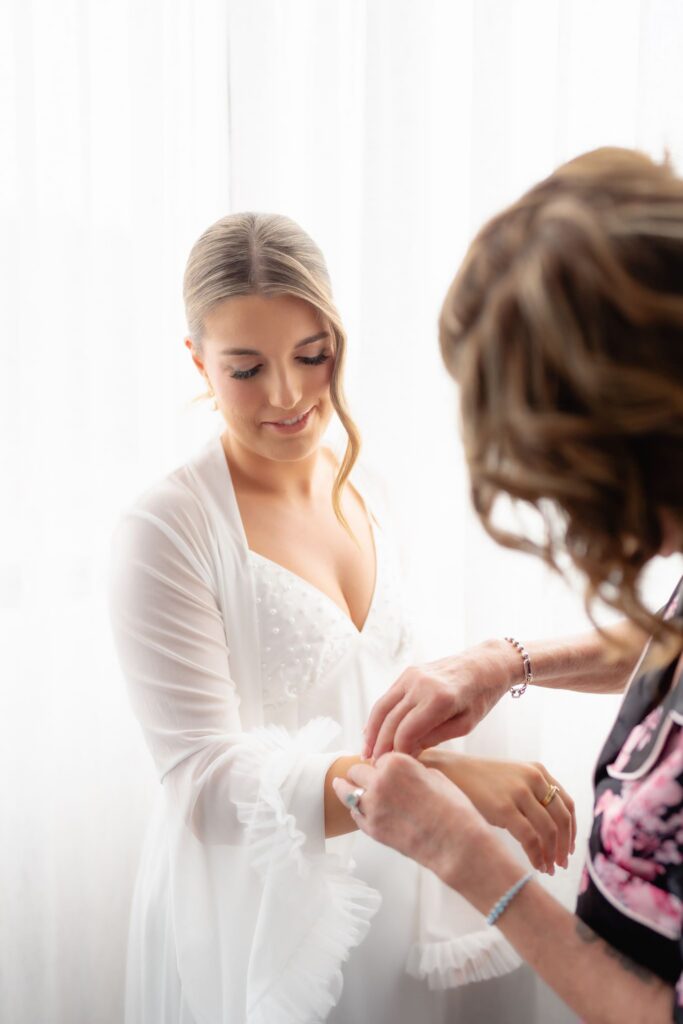 Bride's mum fastening a bracelet on her before Botanic Gardens and Industry26 wedding