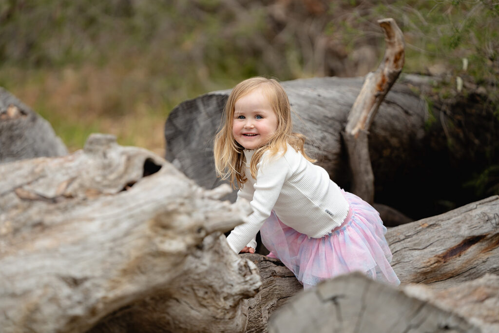 Ivy exploring a fallen log during a Balyang Sanctuary family session