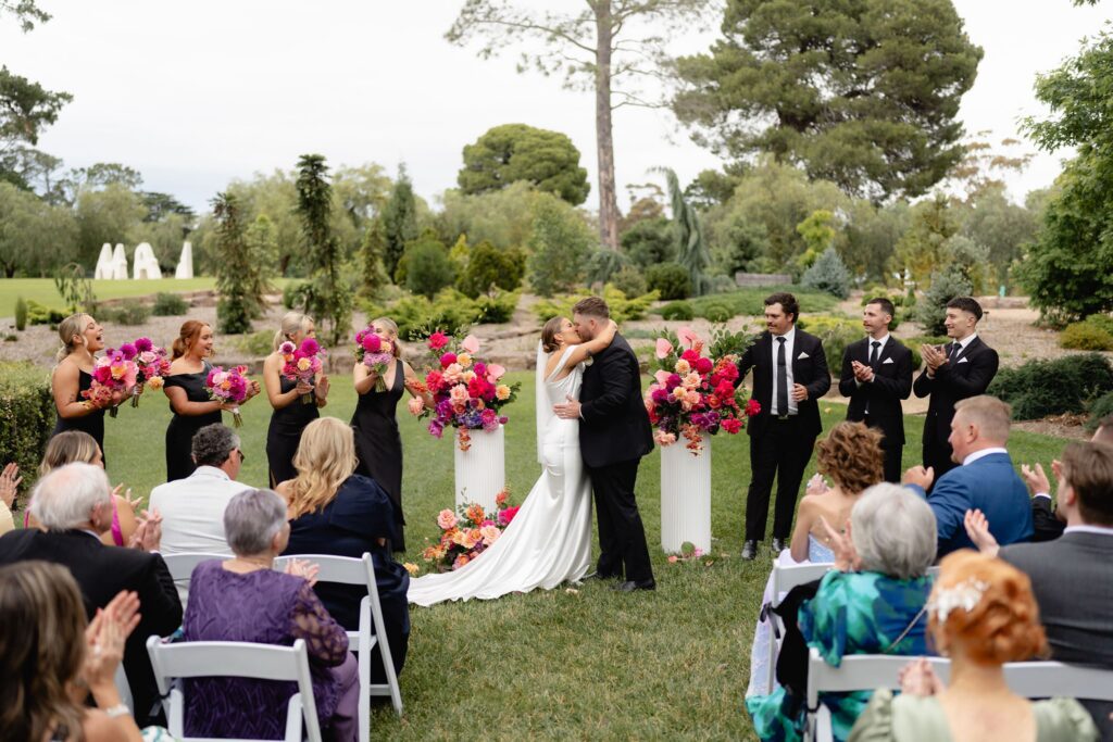 Bride and groom sharing their first kiss at Geelong Botanic Gardens wedding ceremony