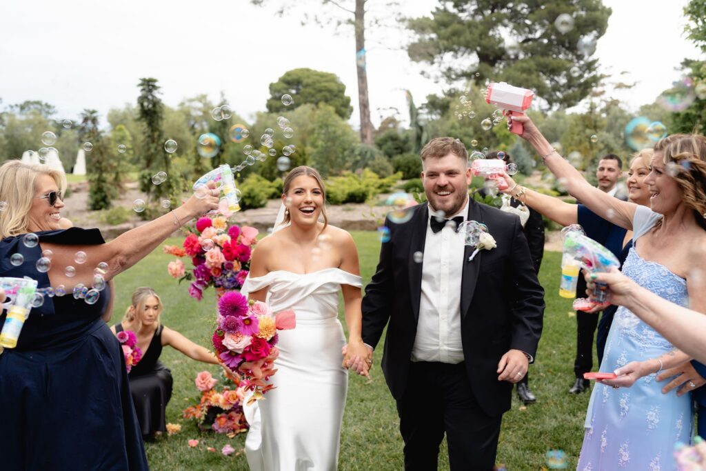 Bubbles exit with cheering guests at Geelong Botanic Gardens wedding