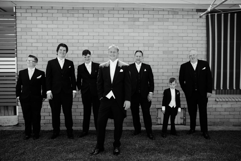 Groom and his groomsmen standing by a Brick wall before the wedding at the Batesford Hotel.