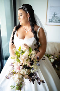 Bride standing by a window before her wedding at the Batesford Hotel.